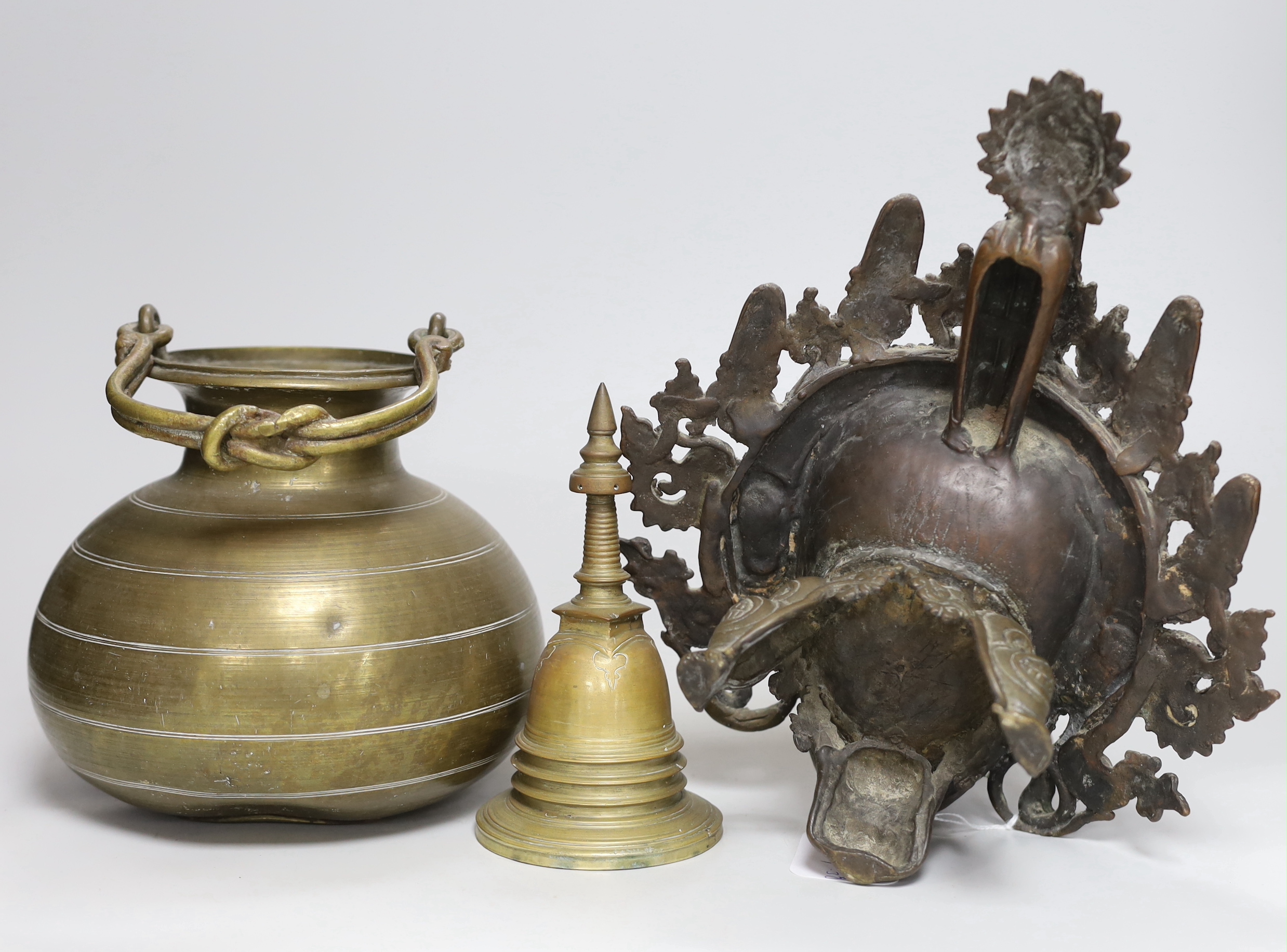 A Tibetan bronze Mahakala mask censer, a stupa shaped bell and a Ceylonese Lota bronze vessel, censer 29cm deep